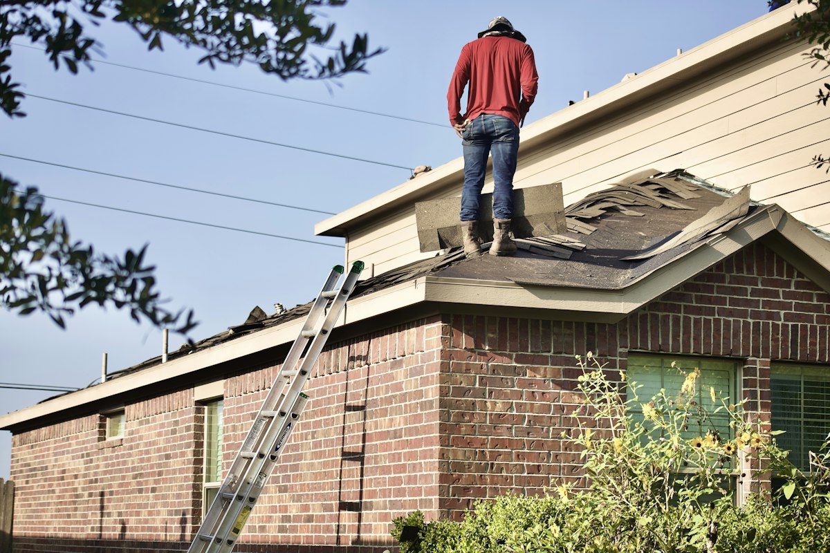 Professional Roofer Installing Shingles on Residential Roof